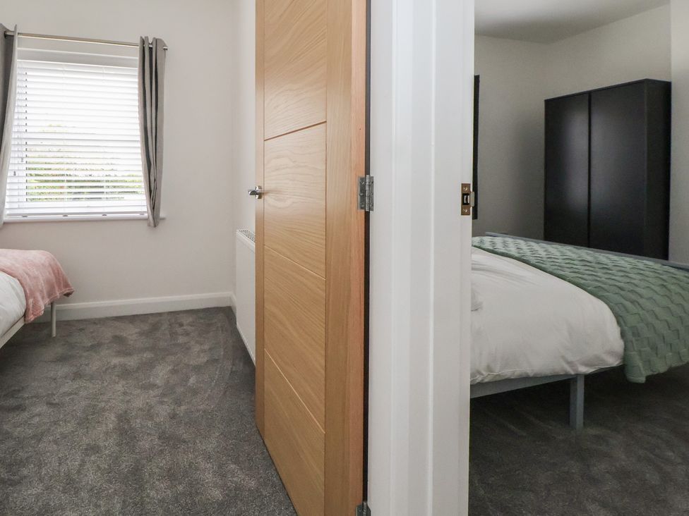 A bedroom with two beds and a window at 5 Marsh Lane Flint