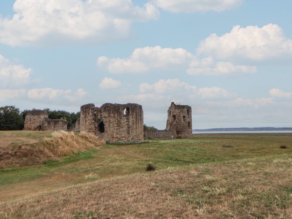 Ruins of a historical structure in a grassy field near water at 5 Marsh Lane in Flint