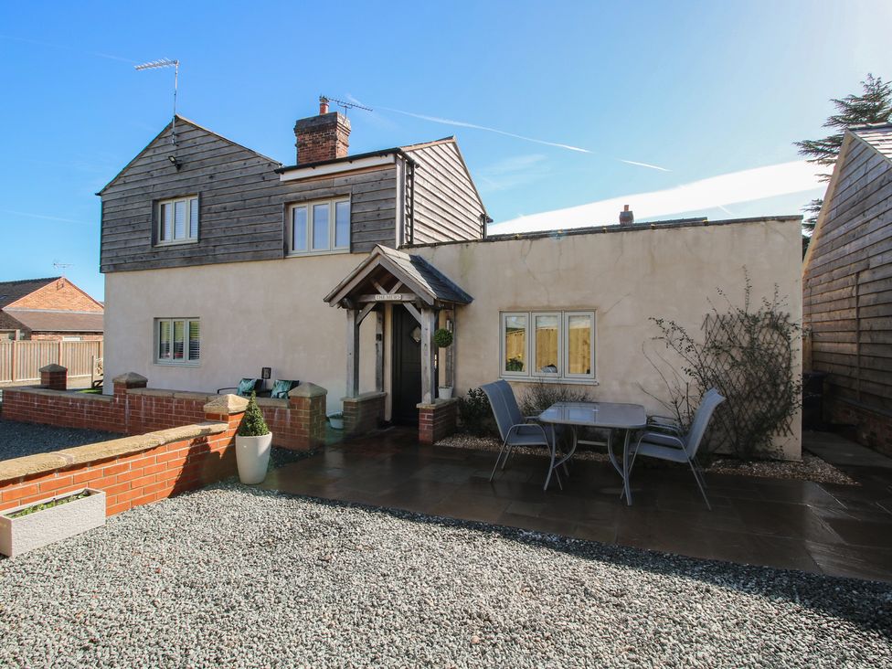 An outdoor area with a house and seating at Yocking Gate Mews near Whitchurch