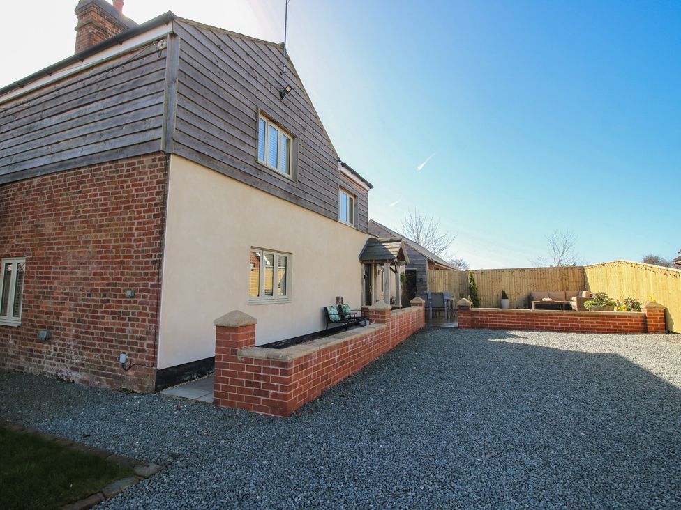 An outdoor area with a house and seating at Yocking Gate Mews near Whitchurch