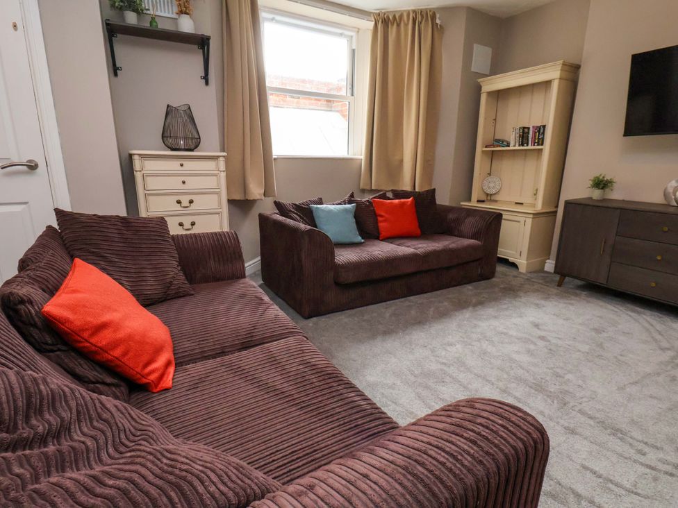 A living room with sofas and a window at The Corner House in Scarborough