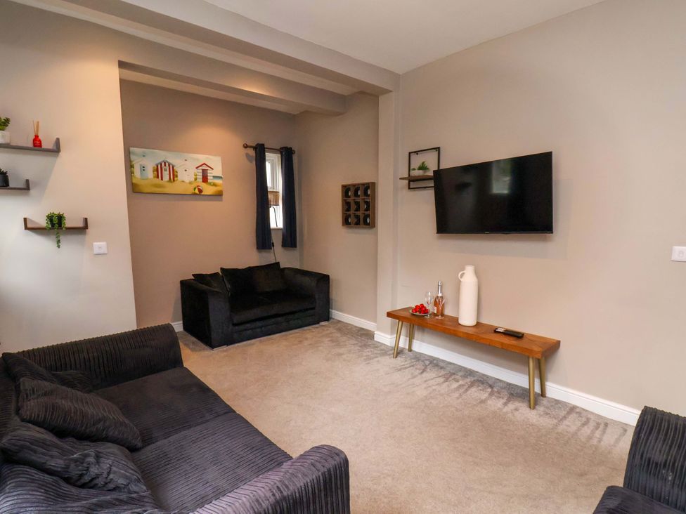 A living room with a sofa and television at The Corner House in Scarborough