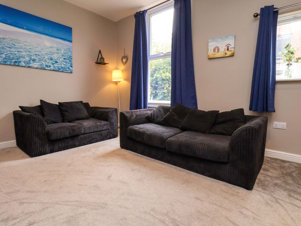 A living room with two sofas and a lamp at The Corner House in Scarborough