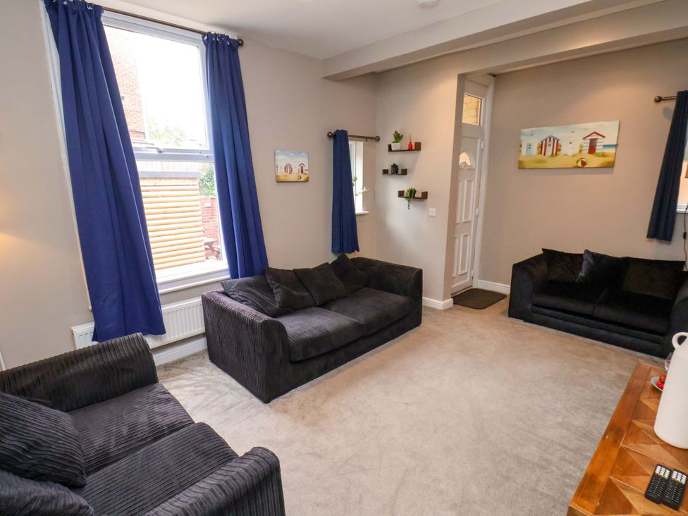 A living room with sofas and a table at The Corner House in Scarborough