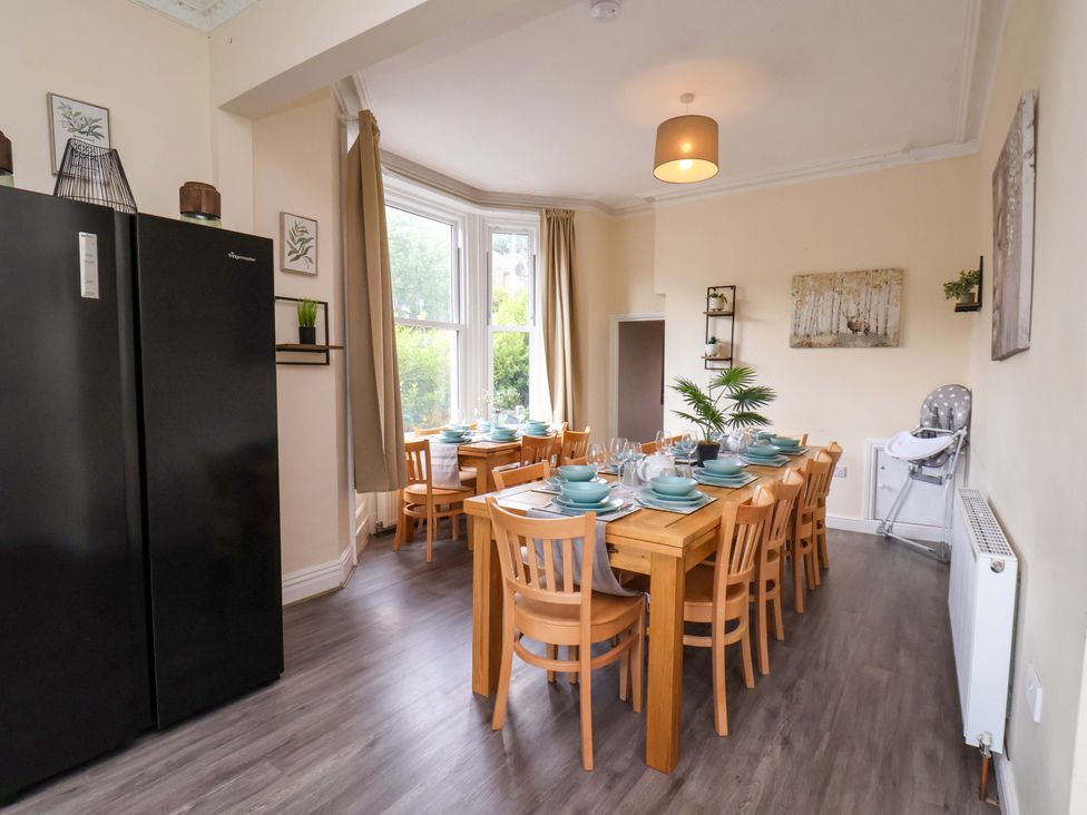 A dining room with a large table and chairs at The Corner House in Scarborough