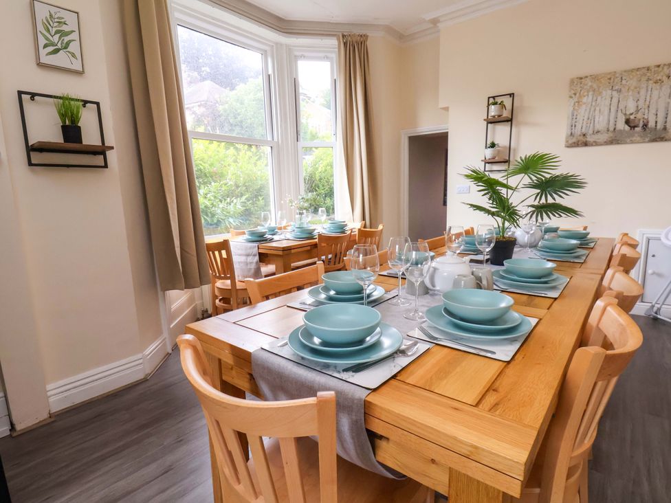 A dining room with a table set for meals at The Corner House in Scarborough