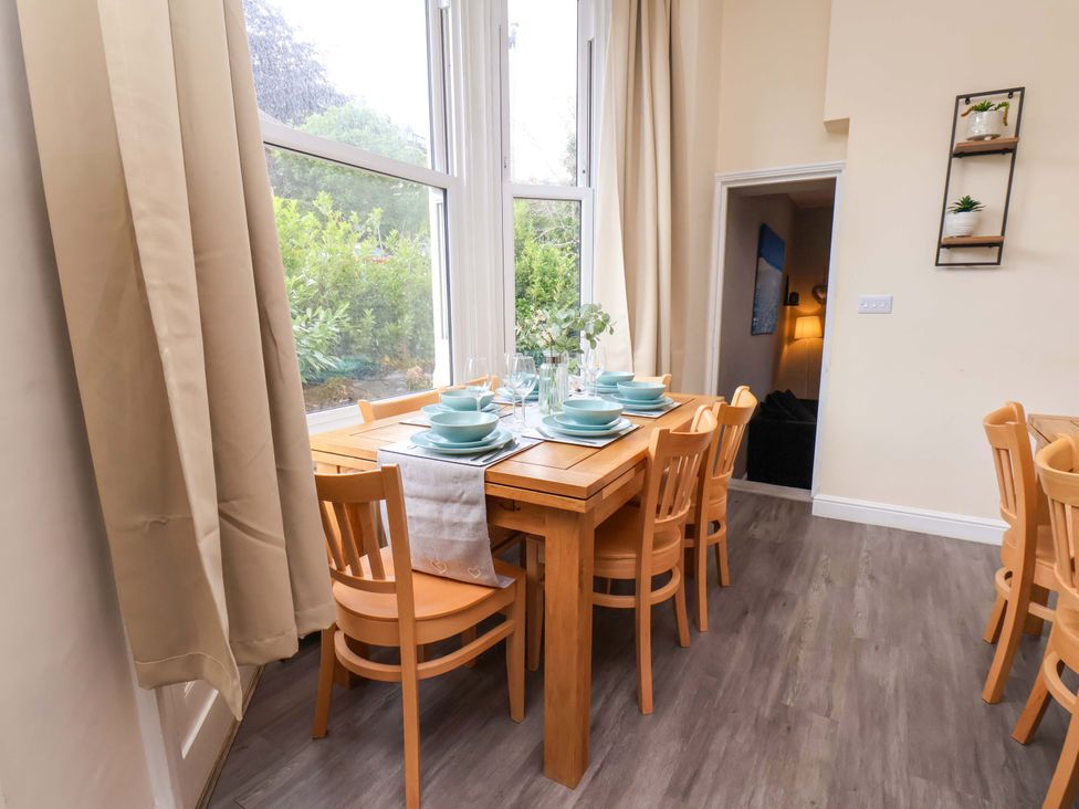 A dining room with a wooden table set for a meal at The Corner House in Scarborough