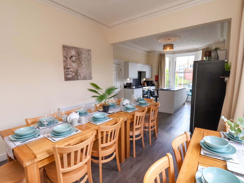 A dining room with a large table set for dinner at The Corner House in Scarborough