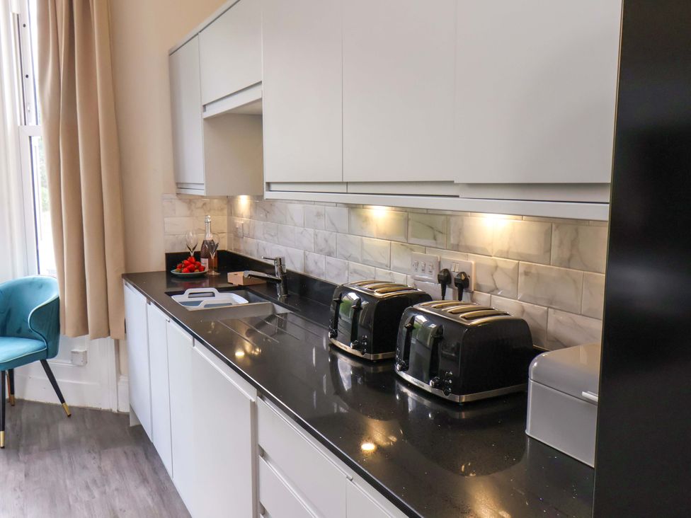 A kitchen with a sink and three toasters at The Corner House in Scarborough