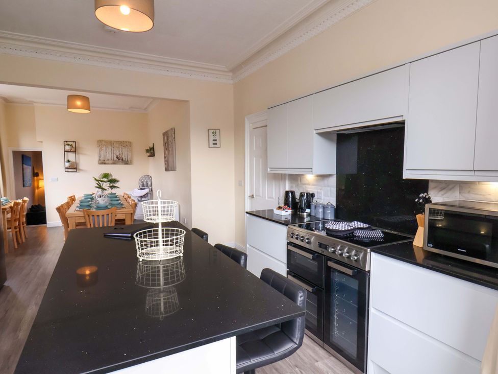 A kitchen with a countertop, stove, and dining area at The Corner House Scarborough