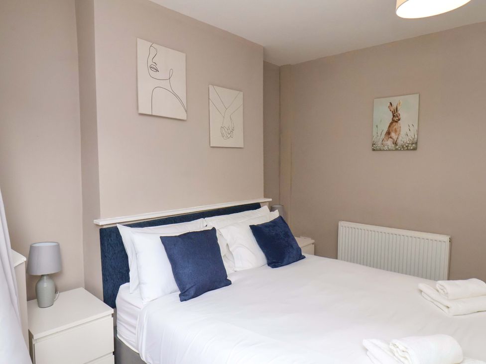 A bedroom with a bed and wall art at The Corner House in Scarborough