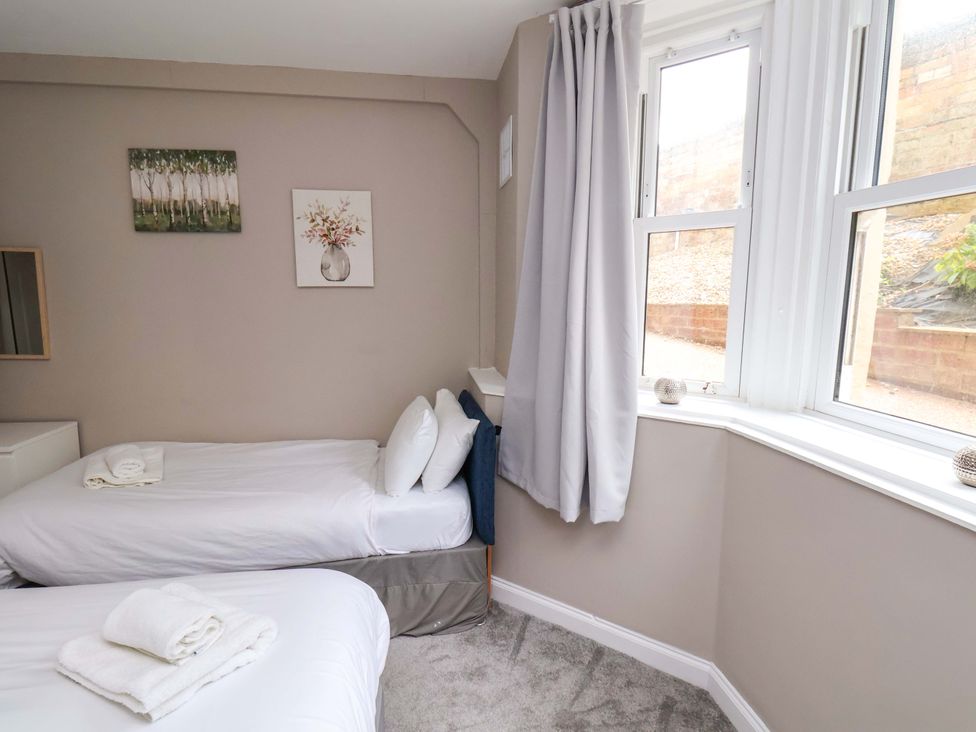A bedroom with two beds and a window at The Corner House in Scarborough