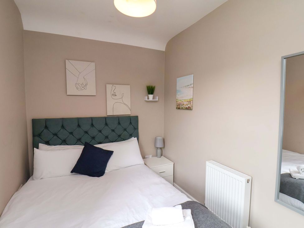 A bedroom with a bed and artwork on the wall at The Corner House in Scarborough