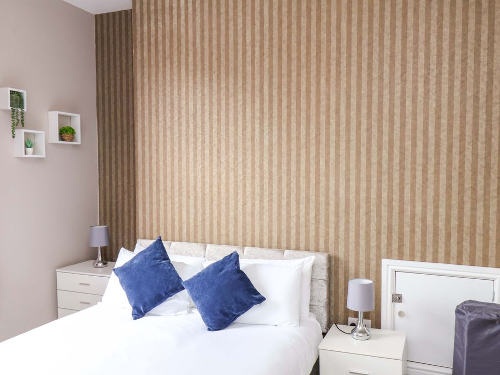 A bedroom with a bed and nightstands at The Corner House in Scarborough