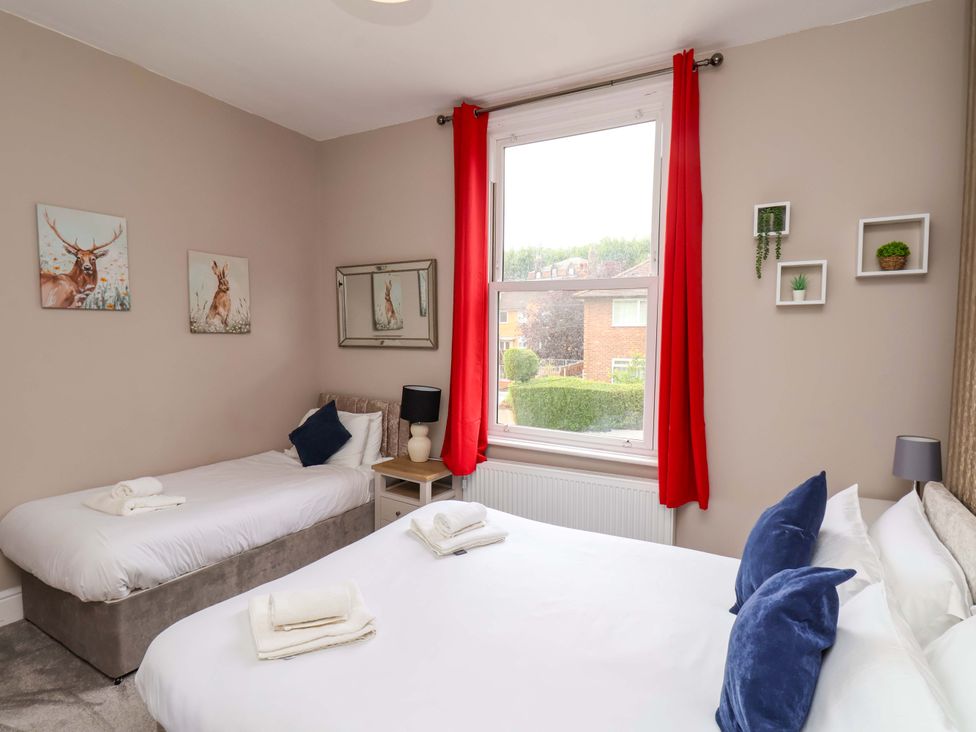 A bedroom with two beds and wall art at The Corner House in Scarborough