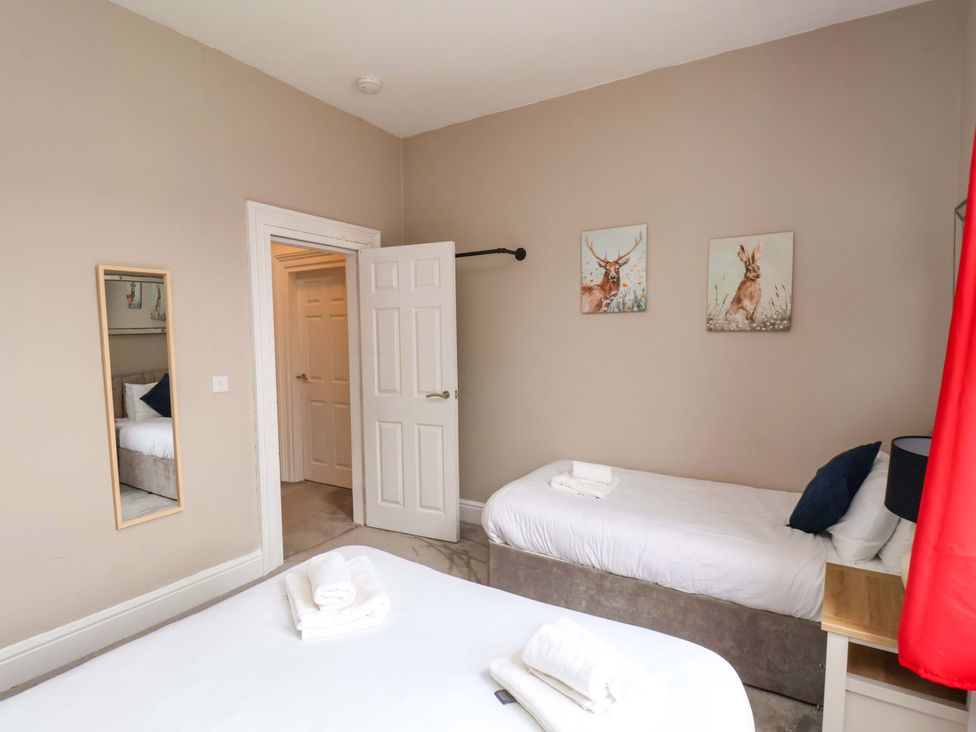 A bedroom with two beds and wall art at The Corner House in Scarborough