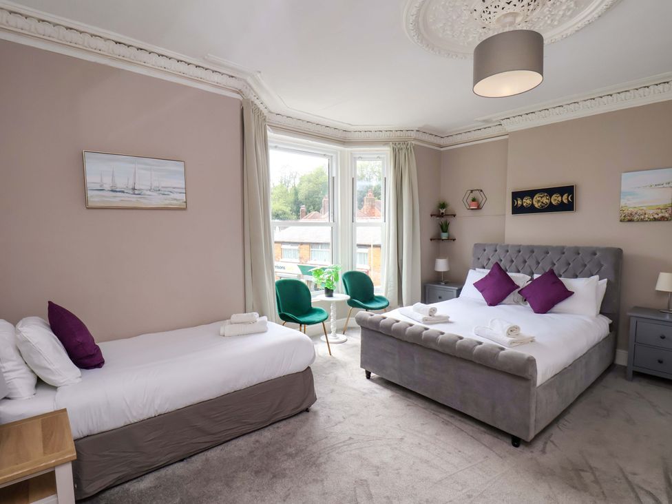 A bedroom with two beds and natural light at The Corner House in Scarborough