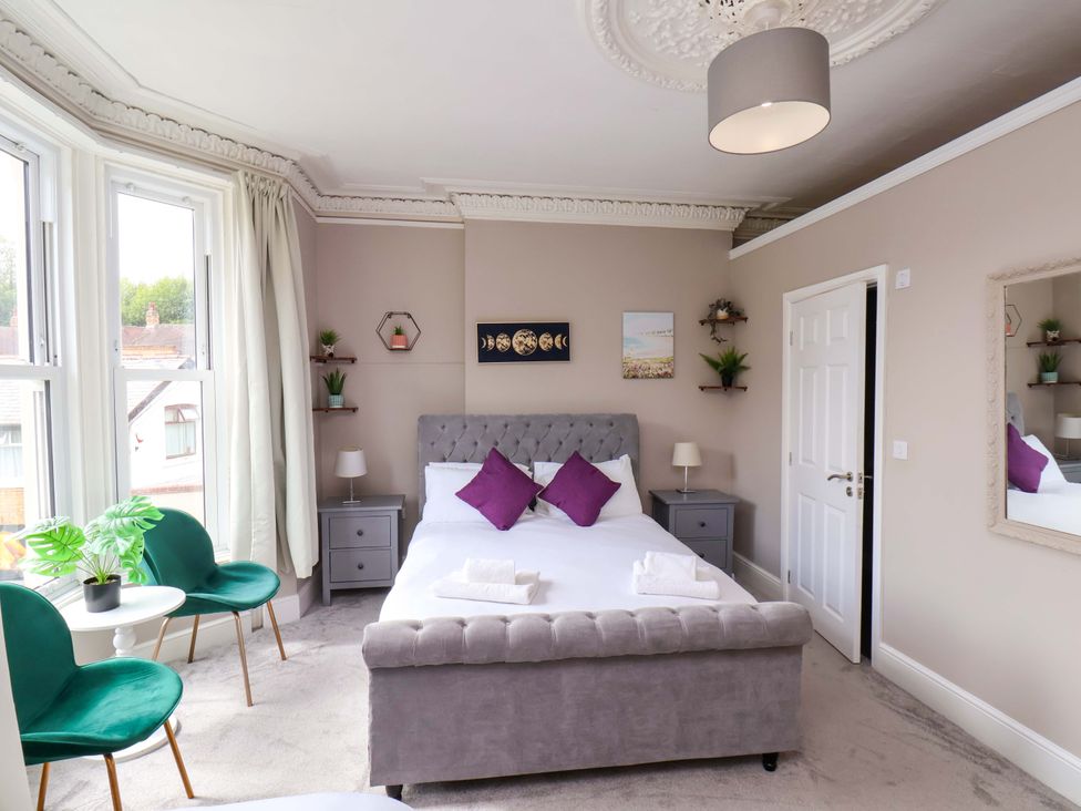A bedroom with a bed and nightstand at The Corner House in Scarborough