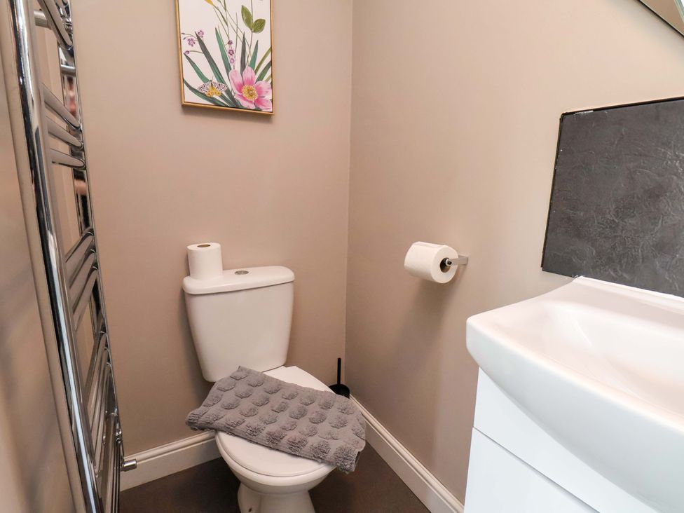 A bathroom with a toilet, wash basin and towel rack at The Corner House in Scarborough