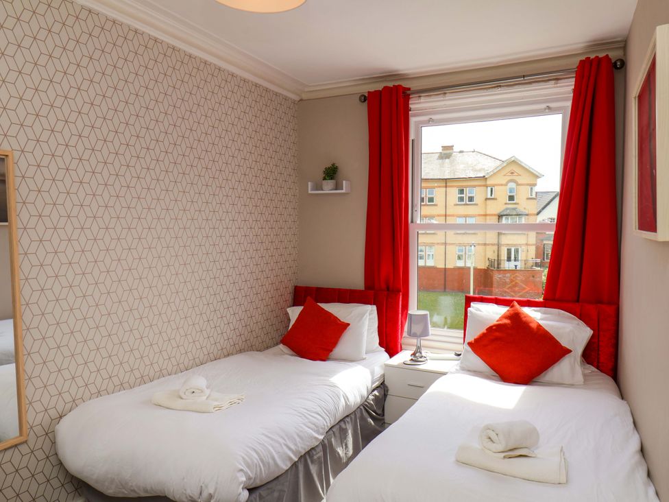 A bedroom with two beds and a window at The Corner House in Scarborough