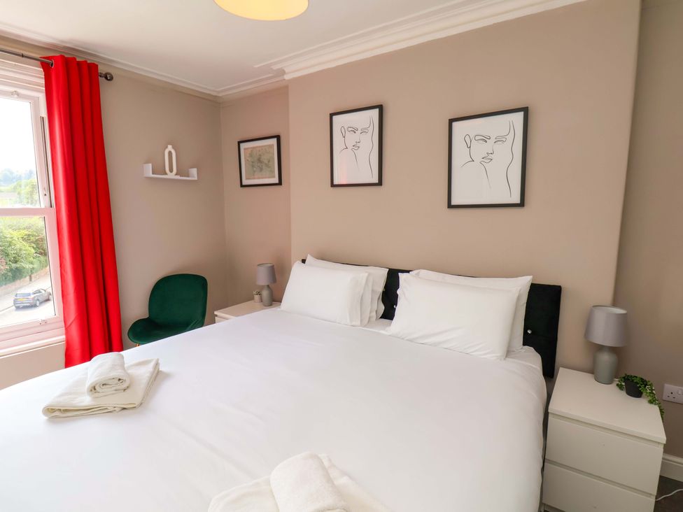 A bedroom with a bed and nightstands at The Corner House in Scarborough