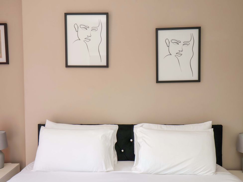 A bedroom with a bed and wall art at The Corner House in Scarborough