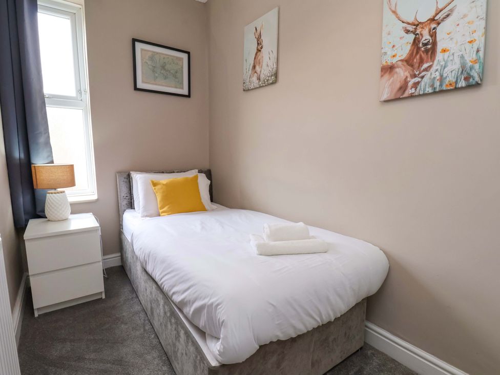 A bedroom with a single bed and a lamp at The Corner House in Scarborough