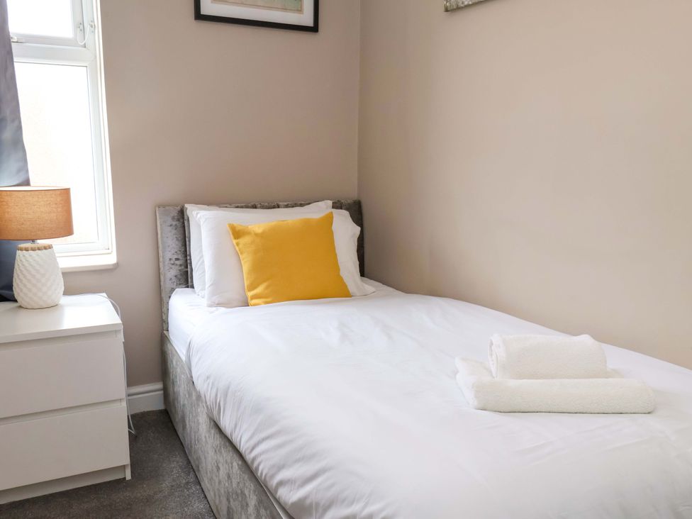 A bedroom with a single bed and a bedside table at The Corner House in Scarborough