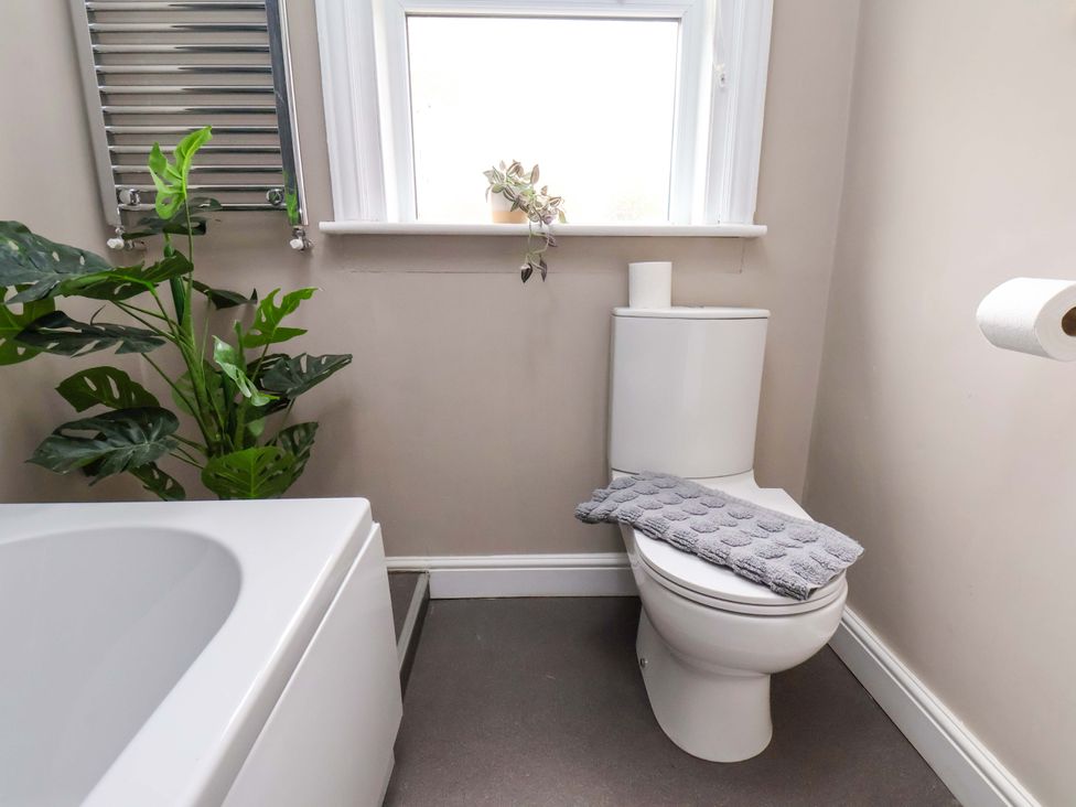 A bathroom with a toilet and bathtub at The Corner House in Scarborough