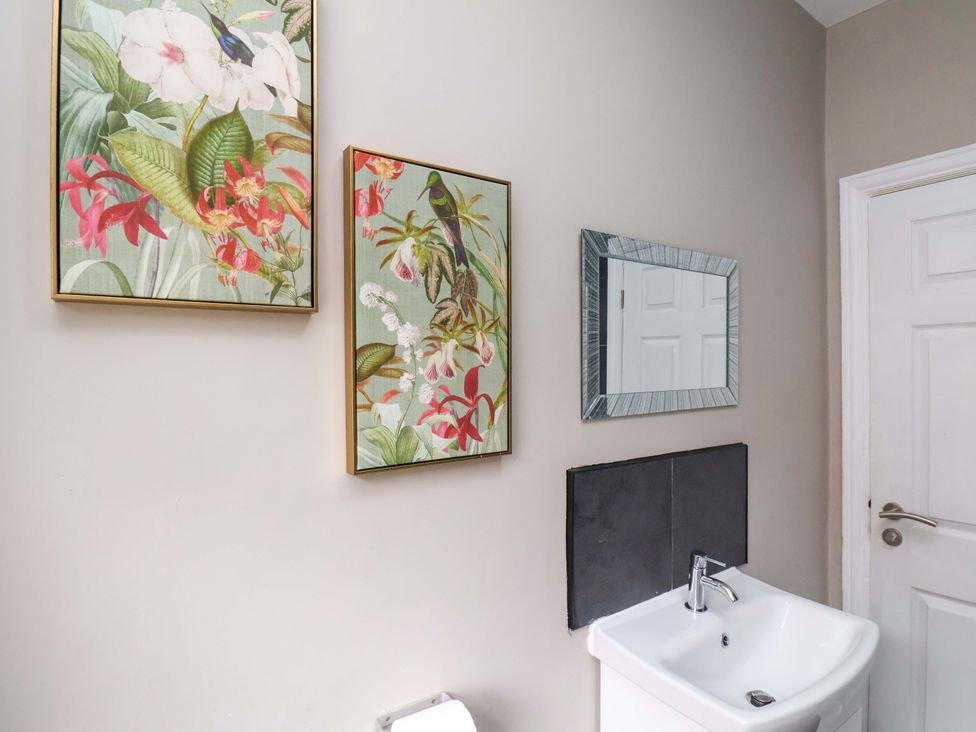 A bathroom with a sink and wall art at The Corner House in Scarborough