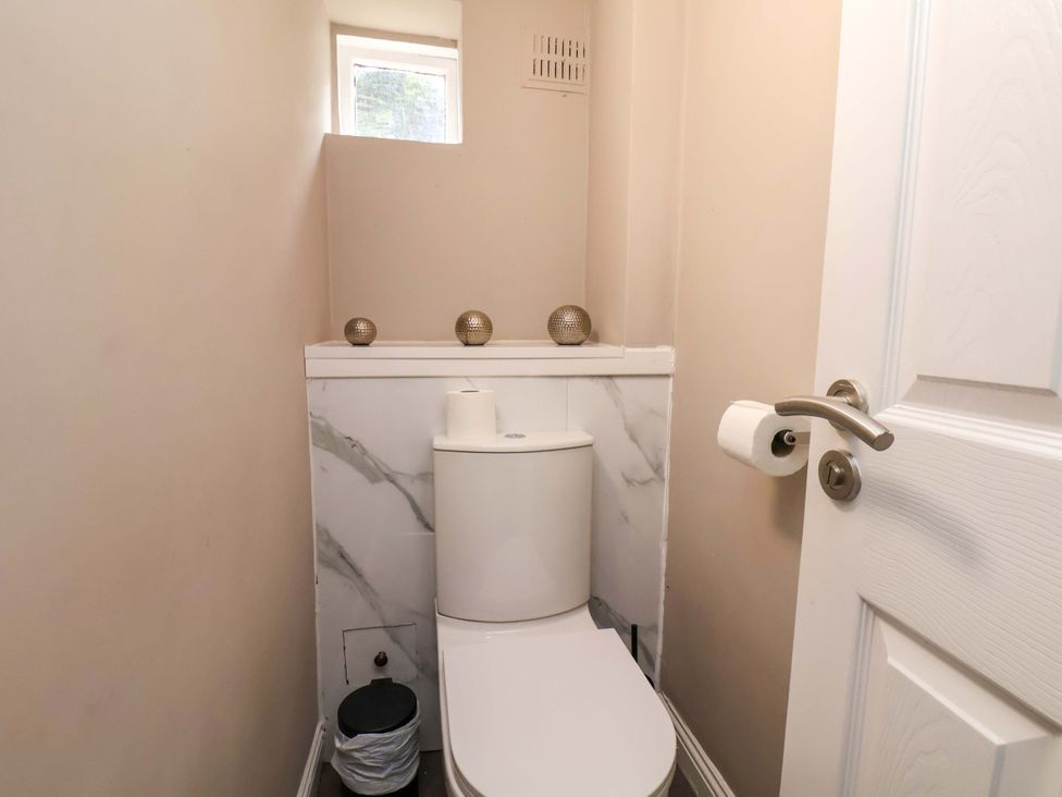 A bathroom with a toilet and a window at The Corner House in Scarborough