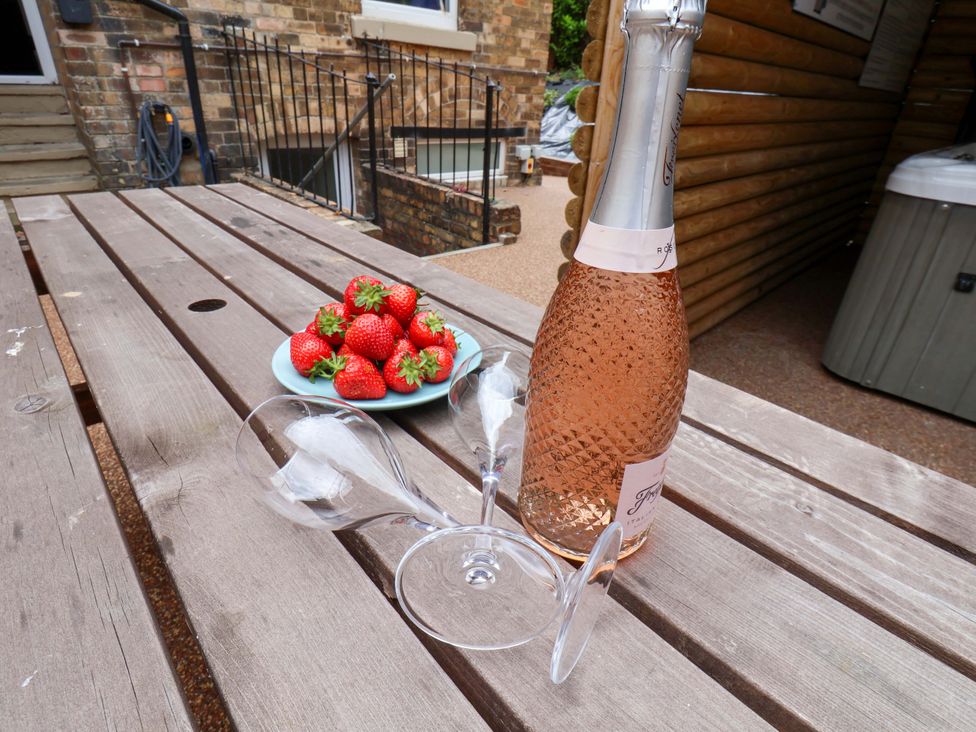 A table with a bottle of rosé wine, wine glasses, and strawberries at The Corner House in Scarborough