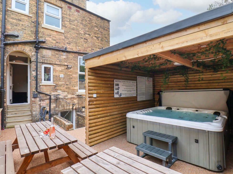 An outdoor area with a hot tub and seating at The Corner House in Scarborough