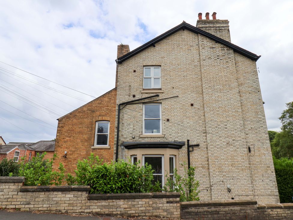 A brick house with windows and garden at The Corner House in Scarborough
