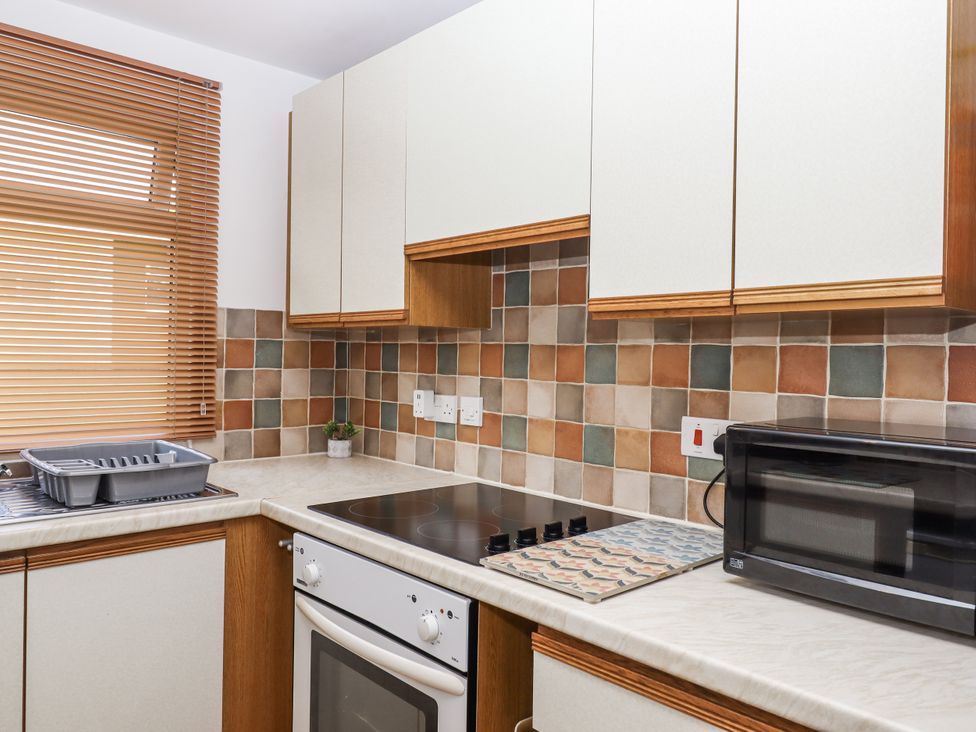 A kitchen with stove, microwave, and cabinets at Driftwood in Dartmouth