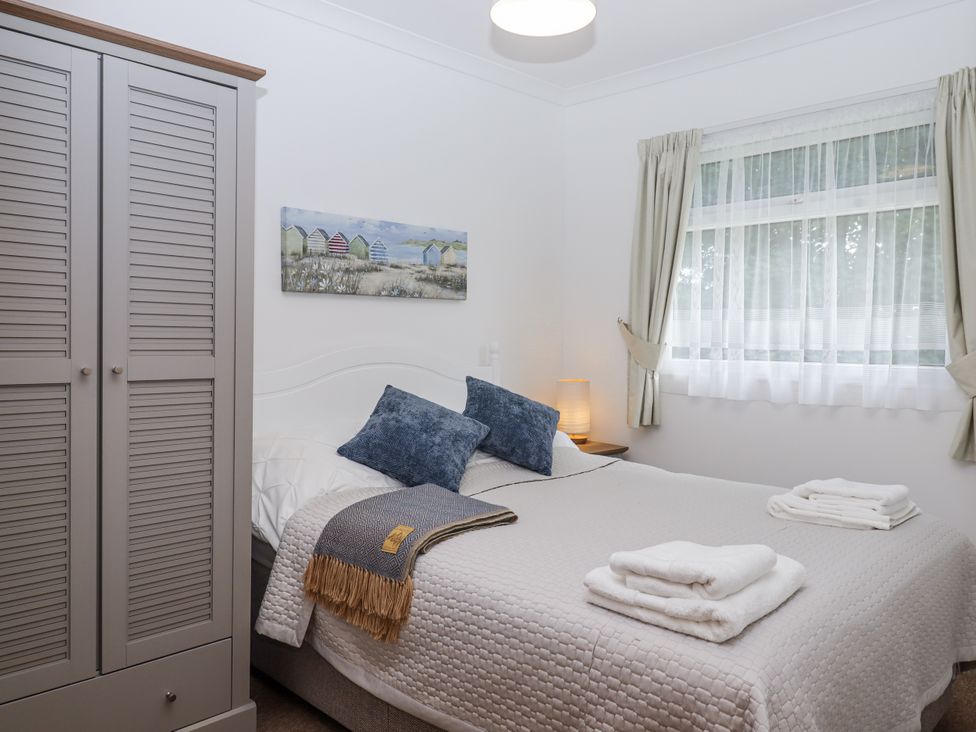A bedroom with a bed and wardrobe at Driftwood in Dartmouth