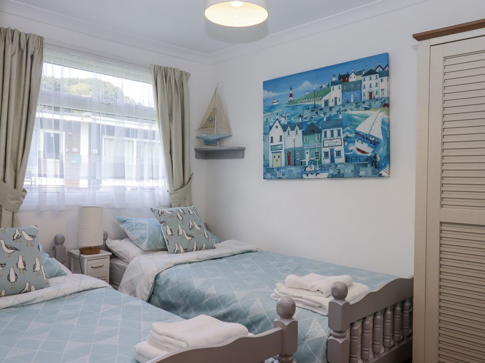 A bedroom with twin beds and nautical decor at Driftwood in Dartmouth