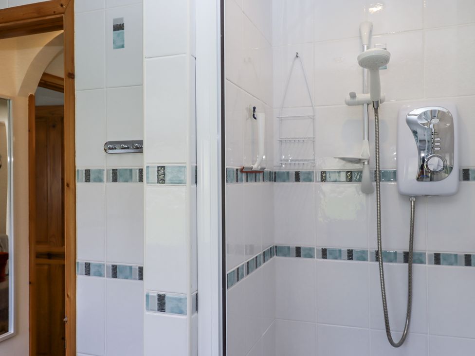 A bathroom with a shower and tiled walls at Driftwood in Dartmouth