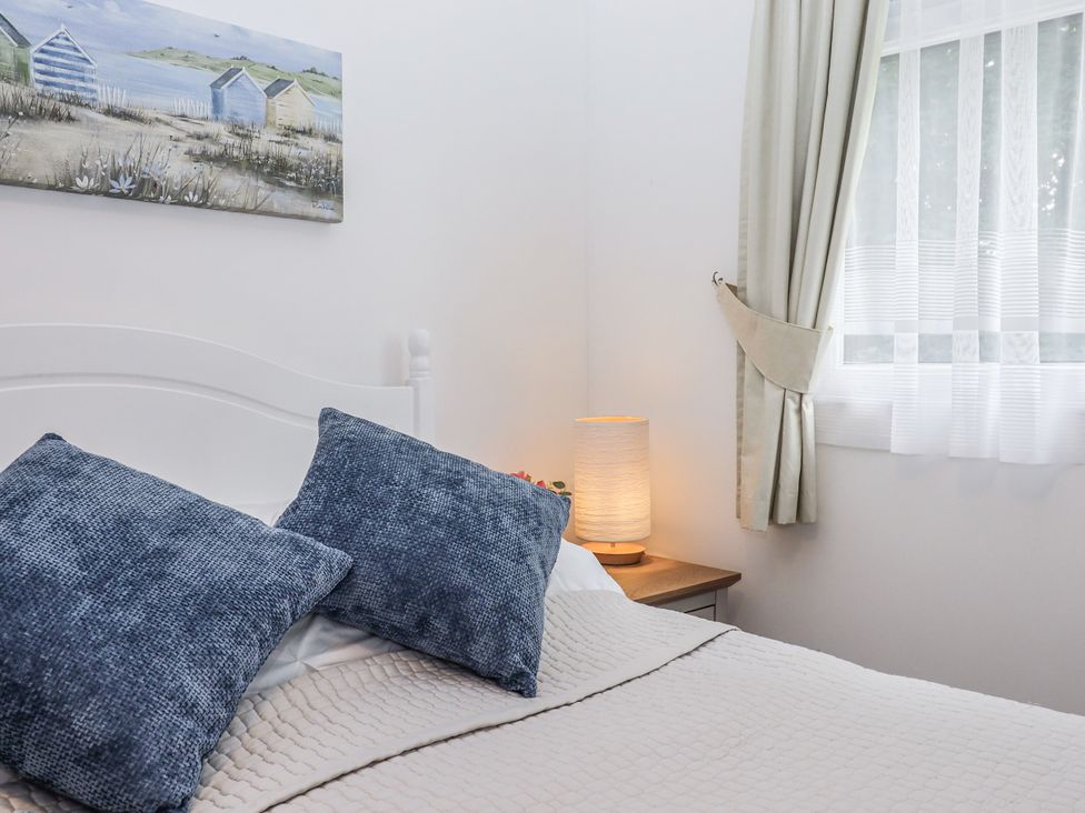 A bedroom with pillows on a bed and a lamp on a bedside table at Driftwood Dartmouth