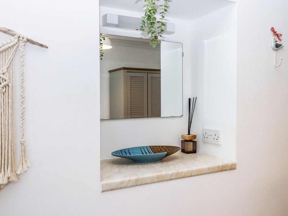 A bathroom with a mirror and decorative bowl at Driftwood in Dartmouth