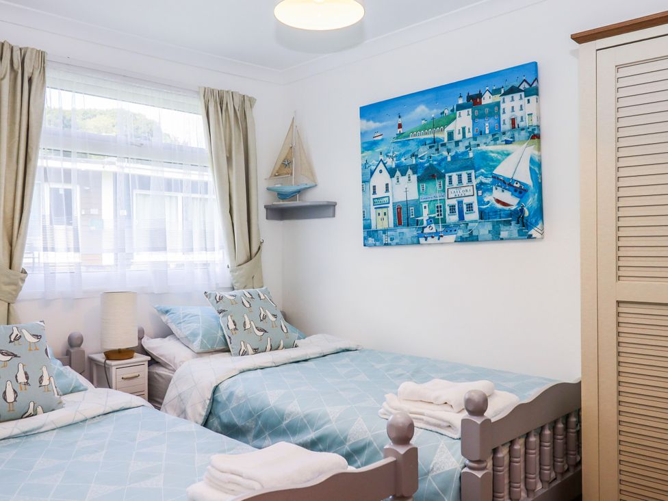 A bedroom with twin beds and a painting at Driftwood in Dartmouth