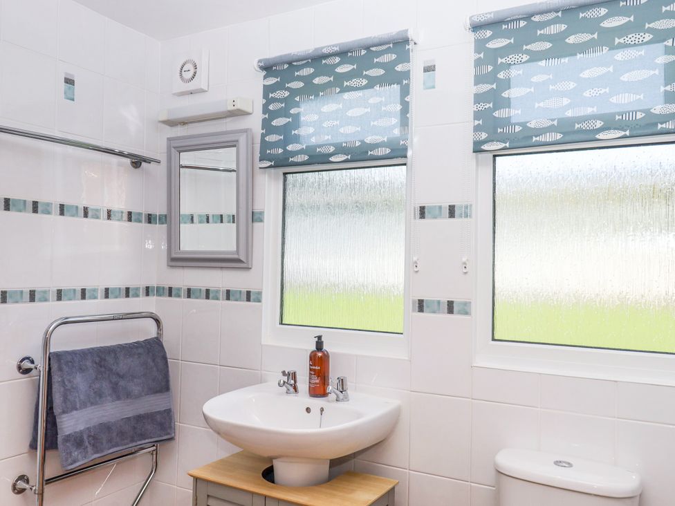 A bathroom with a sink, toilet, and towel rail at Driftwood Dartmouth