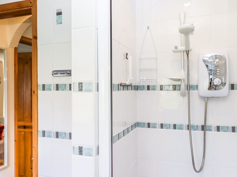A shower with a control unit and tiled wall at Driftwood in Dartmouth