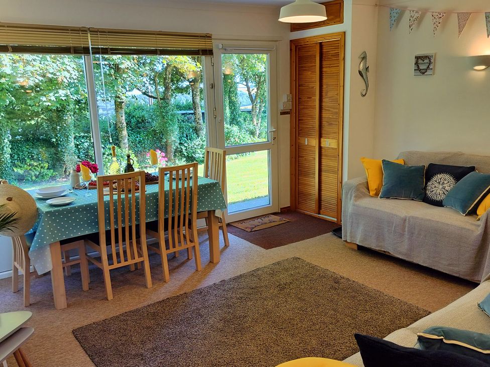 A living room with a dining table and chairs at Driftwood in Dartmouth