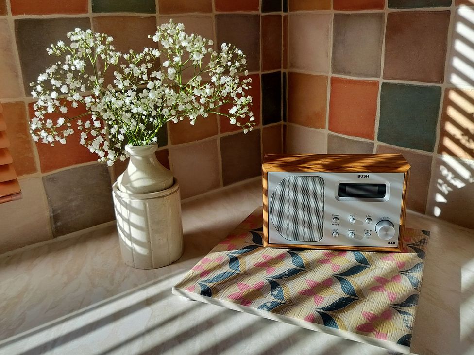A kitchen featuring flowers in a vase and a radio at Driftwood in Dartmouth