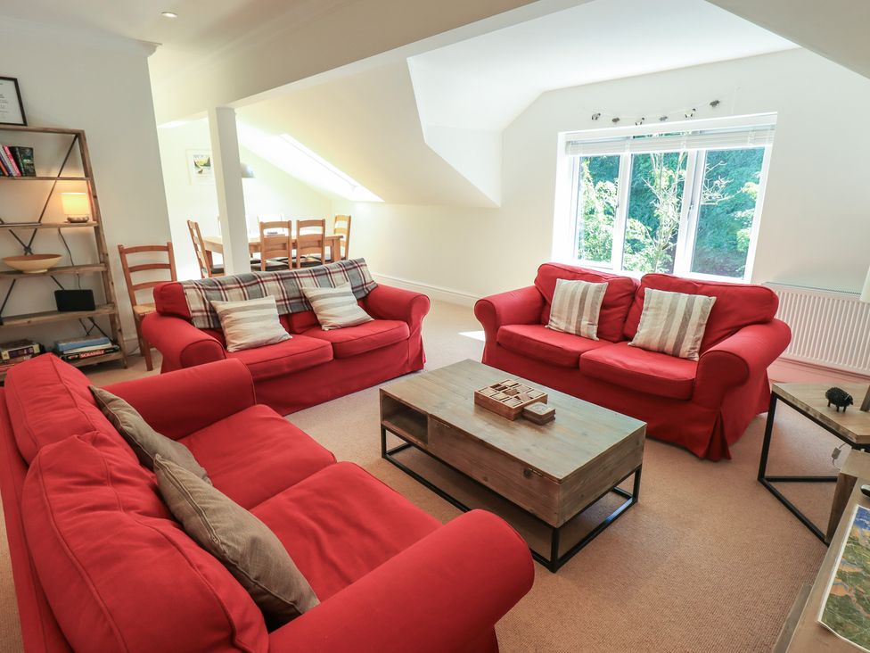 A living room with red sofas and a wooden coffee table at Waterfall in Ambleside