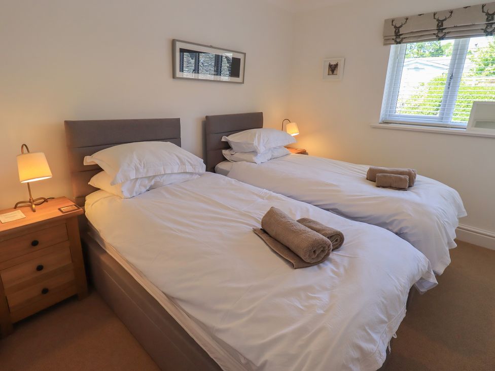 A bedroom with two single beds and a bedside lamp at Waterfall in Ambleside