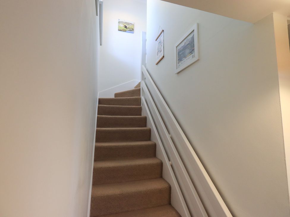 A staircase with carpet and wall frames at Waterfall in Ambleside
