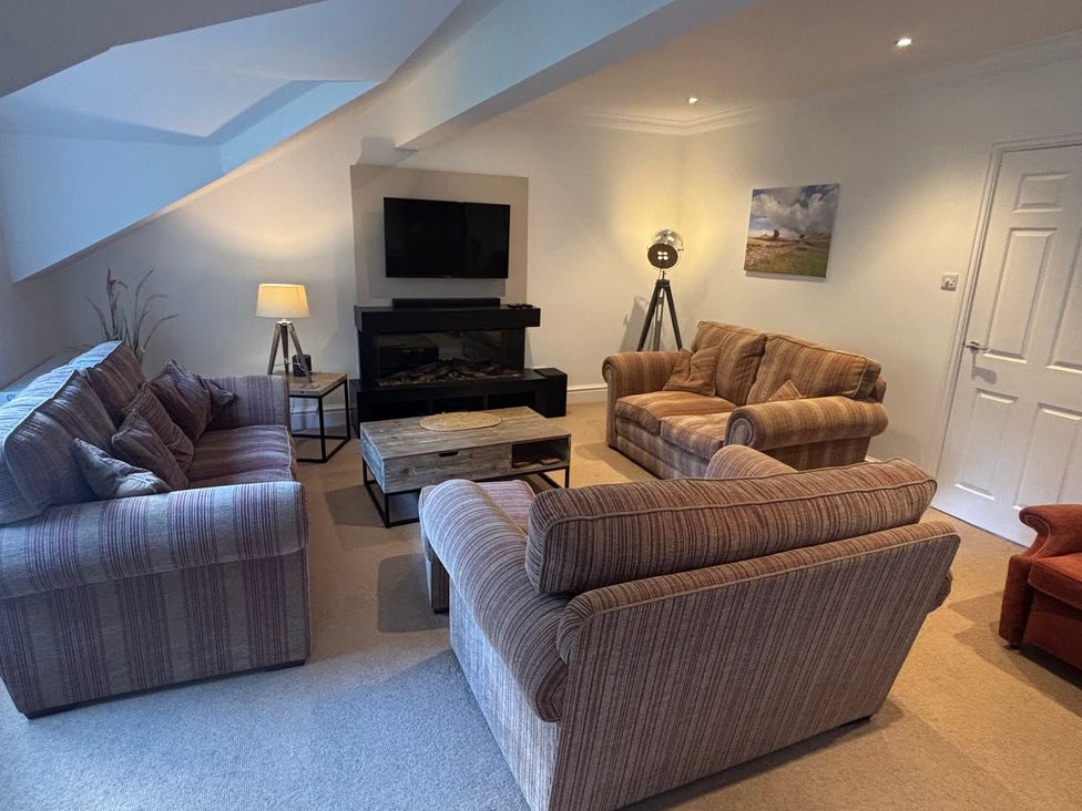 A living room with multiple seating arrangements and a television at Waterfall in Ambleside