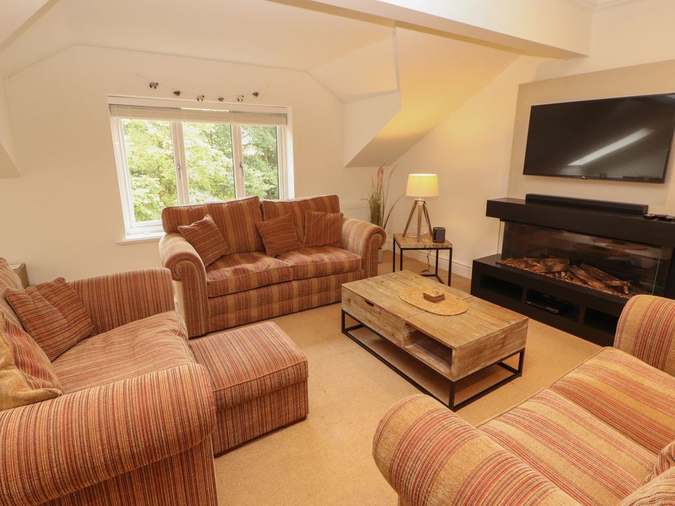 A living room with a sofa, coffee table, and television at Waterfall in Ambleside